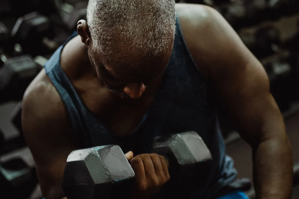 A man working through a controlled dumbbell curl on a bench